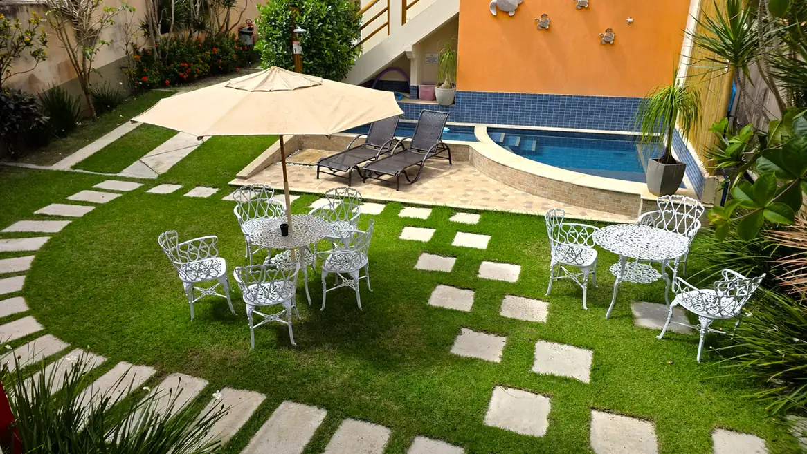 Mesas no jardim junto à piscina